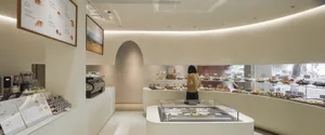 Interior of a modern bakery shop featuring white marble finishes and a selection of baked goods.