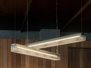 Industrial lighting fixtures made of metal, suspended in a modern setting.