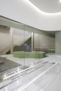 Modern interior space with glass walls and concrete structural elements.