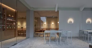 A modern restaurant interior featuring concrete tables and minimalist design elements.