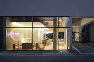 A modern retail storefront with glass windows and seating area.