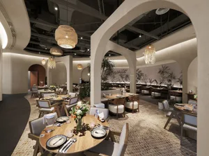 Industrial-themed restaurant interior with wooden tables, bamboo lighting, and plants.