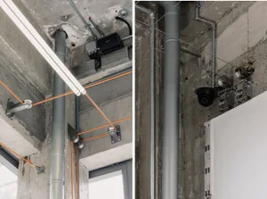 An image showing industrial-style office interior with concrete pipes and cables.