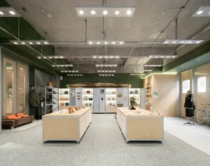 Industrial retail space featuring wooden tables and concrete walls.