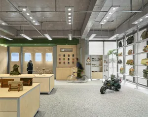 A modern retail store with concrete walls, metal shelving, and wood accents displaying various bags and accessories.