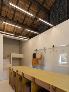 A minimalist workshop featuring glass, concrete, and wooden materials.