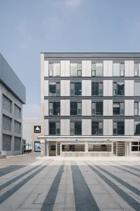 A contemporary modern building constructed with concrete and featuring geometric patterns on its facade and floor.