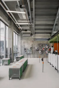 Industrial-style gymnasium with concrete walls, ceilings, and flooring, featuring minimalist design and exposed structural el
