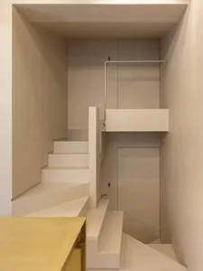 Minimalist modern interior featuring concrete stairs and metal railings.