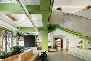 A modern office space with concrete walls and green tiles.