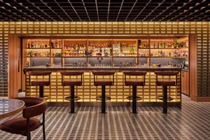 A modern industrial bar featuring a counter made of illuminated glass blocks.