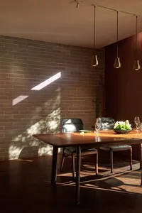 Modern dining room featuring wooden furniture and natural lighting.