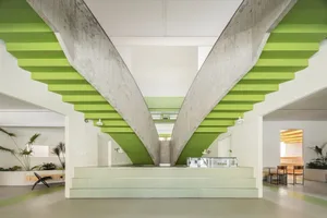 Concrete floor and lime-green paneled lounge area with modern furniture