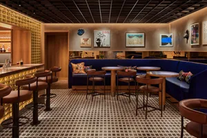 A contemporary restaurant bar featuring wooden furniture, glass walls, and upholstered seating.