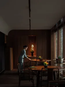A minimalist restaurant interior with dark wood furniture and a warm, inviting atmosphere.