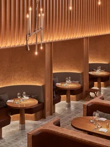 Warm timber restaurant seating with cozy booths and low lighting.