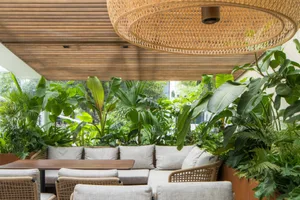 An elegant outdoor seating area featuring modern furniture and lush greenery, designed with a touch of rustic charm.