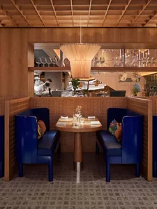 A cozy restaurant interior with modern blue booths and wooden accents.