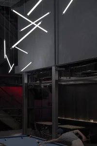 A modern bar interior featuring metal accents and concrete walls.