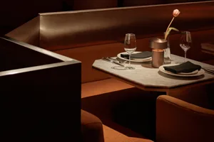Marble table setting with dining chairs in a contemporary restaurant interior.