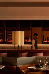A sophisticated restaurant bar with red accents and contemporary lighting.