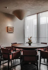 Industrial-style restaurant seating area with wooden tables and chairs.