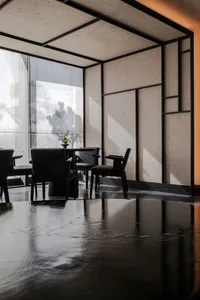A minimalist hotel lobby interior featuring concrete walls and floor, black furniture, and a large window.