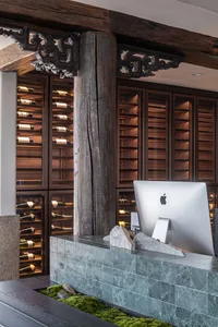 Modern interior design of a wine bar featuring marble accents and a display of wine bottles.