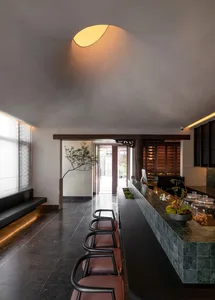 Interior view of a modern lobby featuring stone flooring, wooden accents, and a minimalist design aesthetic.