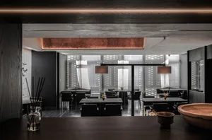 Modern restaurant interior with concrete floor, wooden accents, and glass partitions.