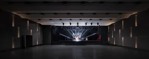 A modern concert hall with a dark interior and black lighting capitals.