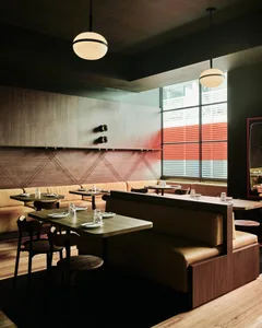 A modern restaurant interior featuring wood and leather elements.