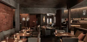 An industrial-themed restaurant with metallic walls, concrete floors, and loft-style design.