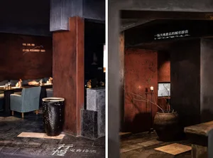 Industrial-style lounge with black concrete walls and a cozy seating area