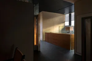 An elegant, modern office reception desk featuring a glass surface and a concrete wall in the background.