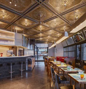 A modern industrial restaurant interior with metallic finishes and wood accents.