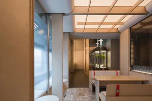 Industrial-style restaurant interior with wooden materials and industrial design elements.