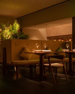 A cozy restaurant interior with wooden tables, cushioned seating, and a warm, inviting atmosphere.