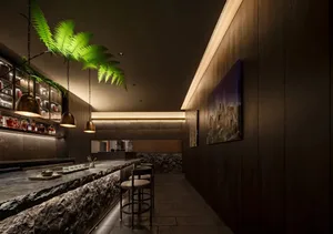 Indoor minimalist environment with metal furniture, dark wood paneling, and natural leaf hanging decor.