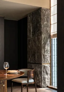 Modern dining area featuring a stone wall