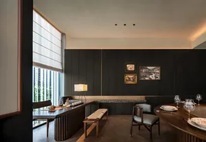 A modern dining room with wooden furniture and a large window.