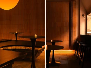 Photo of a modern restaurant interior with brick walls and candlelit tables.