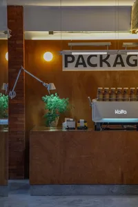 Interior of a modern coffee shop with a wooden counter and metal coffee machine.