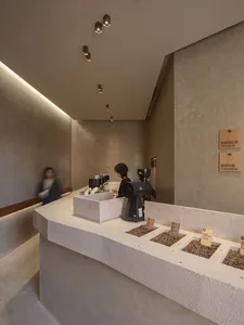 A modern coffee shop with a concrete counter displaying coffee beans from different origins.