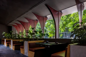 Industrial-style restaurant interior with wooden seating and ceiling