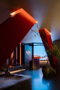 Interior design featuring a modern hotel entry with red columns and a glass ceiling.
