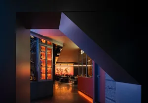 Modern restaurant interior with metal railings and leather seating.