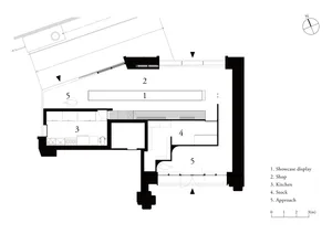 An architectural plan of a small shop with white walls and a gray floor, showing functional zones like showcase display, shop