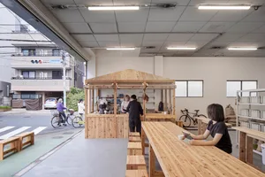 A modern industrial-style coffee shop with wooden features inside and a counter for ordering.