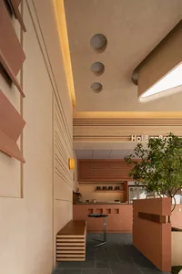 A minimalist coffee shop interior with brick walls and wooden seating.